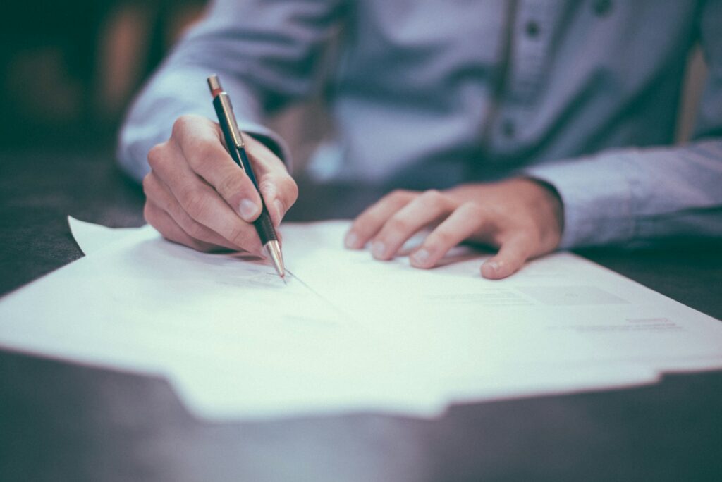 man writing on paper Project Manager Degree